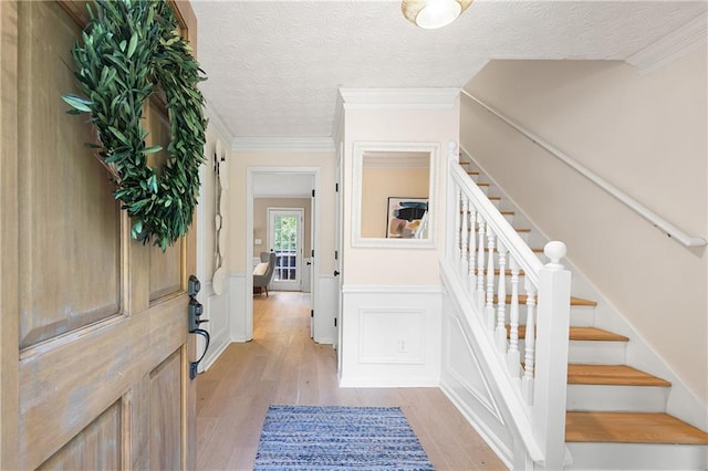 4522 Reva Ct NE, Marietta, GA 30066 - entrance foyer featuring light wood-style floors, stairway, a textured ceiling, and ornamental molding