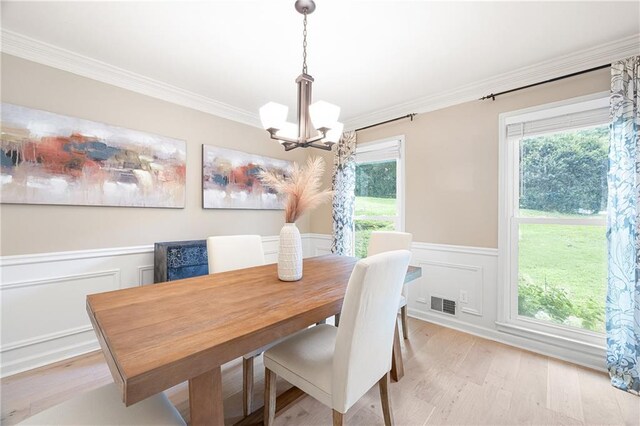 4522 Reva Ct NE, Marietta, GA 30066 - dining space with a chandelier, crown molding, light wood-type flooring, wainscoting, and a decorative wall