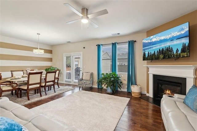 living room with dark hardwood / wood-style flooring and ceiling fan