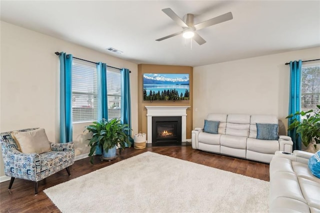 living room with dark wood-type flooring and ceiling fan