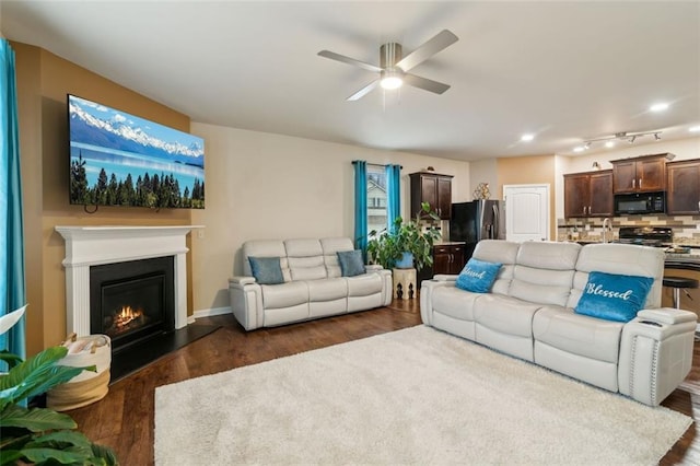 living room featuring dark wood-type flooring and ceiling fan