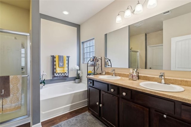 bathroom featuring vanity, separate shower and tub, and hardwood / wood-style floors