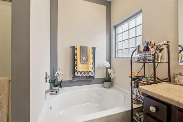 bathroom with a washtub and vanity