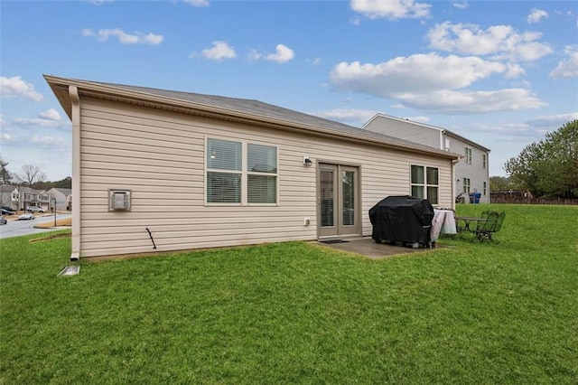 rear view of property featuring a patio and a yard