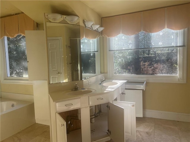 full bath featuring a sink, baseboards, a garden tub, and double vanity