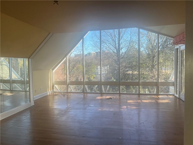 additional living space featuring lofted ceiling and wood finished floors