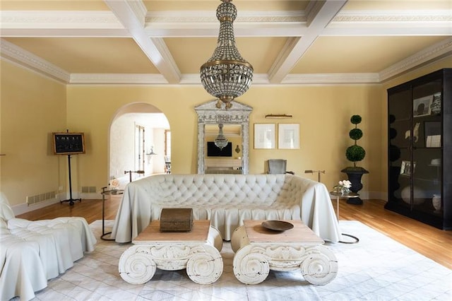 bedroom featuring light hardwood / wood-style flooring, coffered ceiling, ornamental molding, and beam ceiling