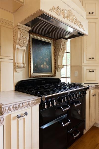 kitchen featuring wood-type flooring, high end range, and premium range hood