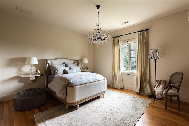 bedroom with a notable chandelier and hardwood / wood-style floors