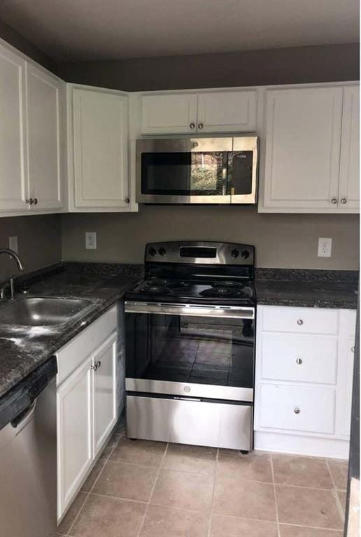 kitchen with appliances with stainless steel finishes, white cabinets, and a sink