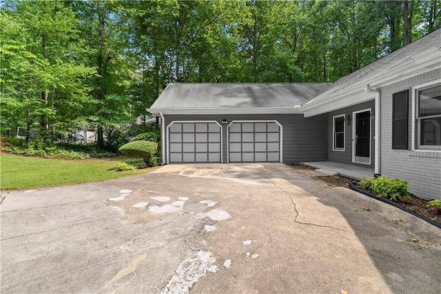 2865 Bryant Ct, Cumming, GA 30040 - view of side of home with an attached garage, brick siding, driveway, and view of scattered trees