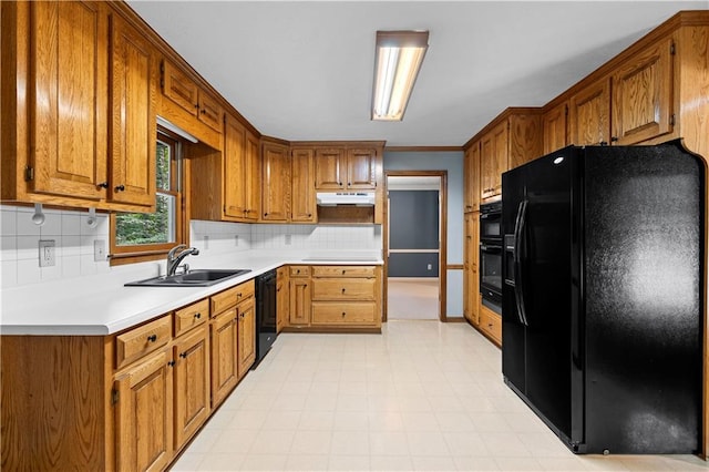 2865 Bryant Ct, Cumming, GA 30040 - kitchen featuring black appliances, under cabinet range hood, a sink, brown cabinetry, and tasteful backsplash