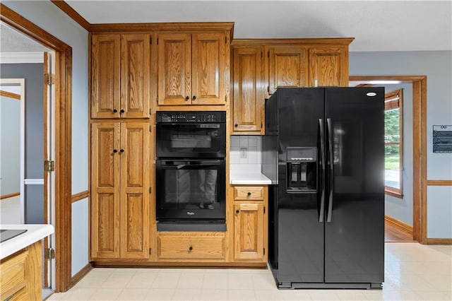 2865 Bryant Ct, Cumming, GA 30040 - kitchen featuring black appliances, light countertops, baseboards, decorative backsplash, and brown cabinetry