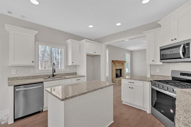 kitchen with appliances with stainless steel finishes, sink, and white cabinets