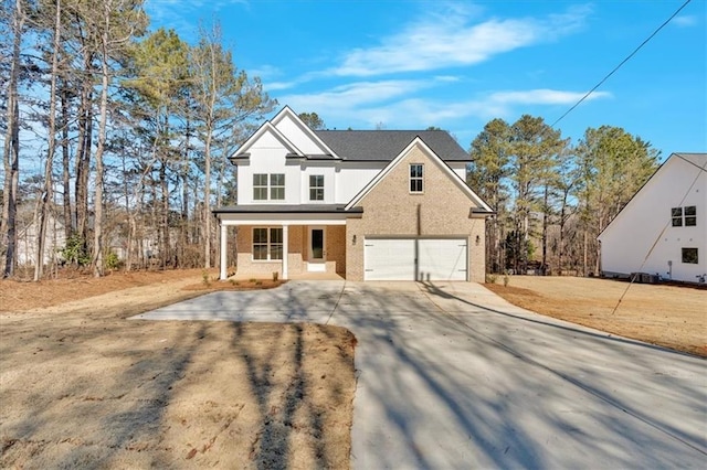 view of front of property with a garage, a front lawn, and a porch