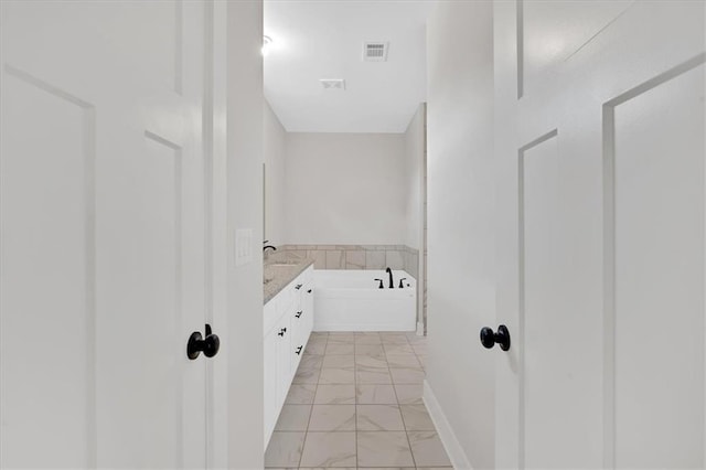 bathroom with vanity and a bath