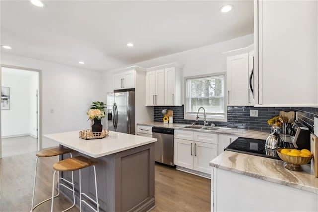 2206 Loring Ct, Decatur, GA 30032 - kitchen featuring decorative backsplash, stainless steel appliances, light wood finished floors, a sink, and a center island