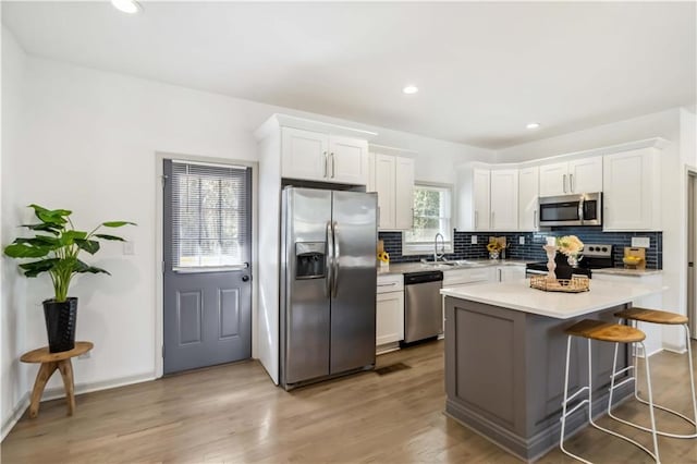 2206 Loring Ct, Decatur, GA 30032 - kitchen featuring decorative backsplash, stainless steel appliances, light countertops, a sink, and white cabinetry