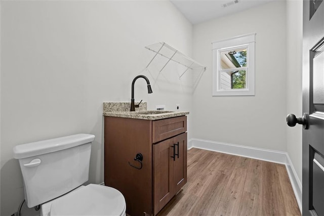 130 W Lake Blvd, Carrollton, GA 30116 - half bath featuring wood finished floors, toilet, baseboards, and vanity