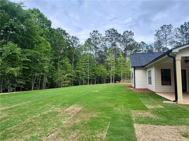 view of green lawn with a patio and a ceiling fan
