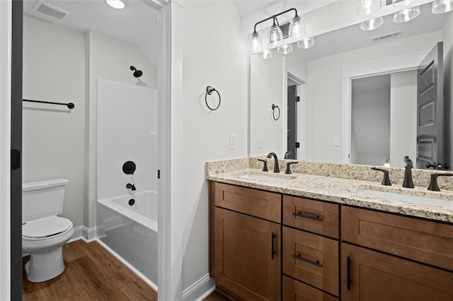 130 W Lake Blvd, Carrollton, GA 30116 - bathroom with wood finished floors, toilet, double vanity, bathing tub / shower combination, and baseboards