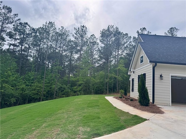view of grassy yard with concrete driveway
