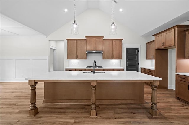 130 W Lake Blvd, Carrollton, GA 30116 - kitchen featuring high vaulted ceiling, light countertops, brown cabinets, a kitchen breakfast bar, and a sink
