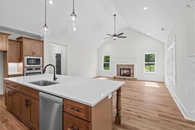 130 W Lake Blvd, Carrollton, GA 30116 - kitchen with appliances with stainless steel finishes, a sink, brown cabinets, light wood-type flooring, and healthy amount of natural light