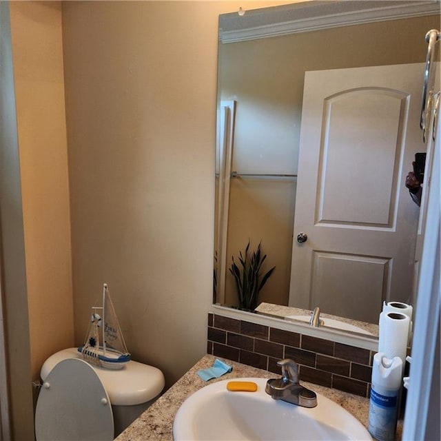 bathroom with vanity, tasteful backsplash, and toilet