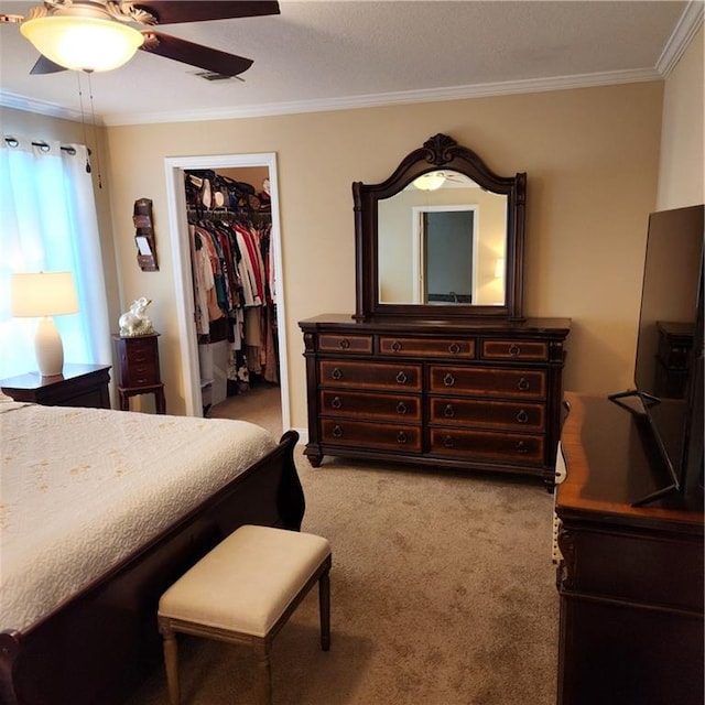carpeted bedroom featuring ornamental molding, a closet, visible vents, and a spacious closet