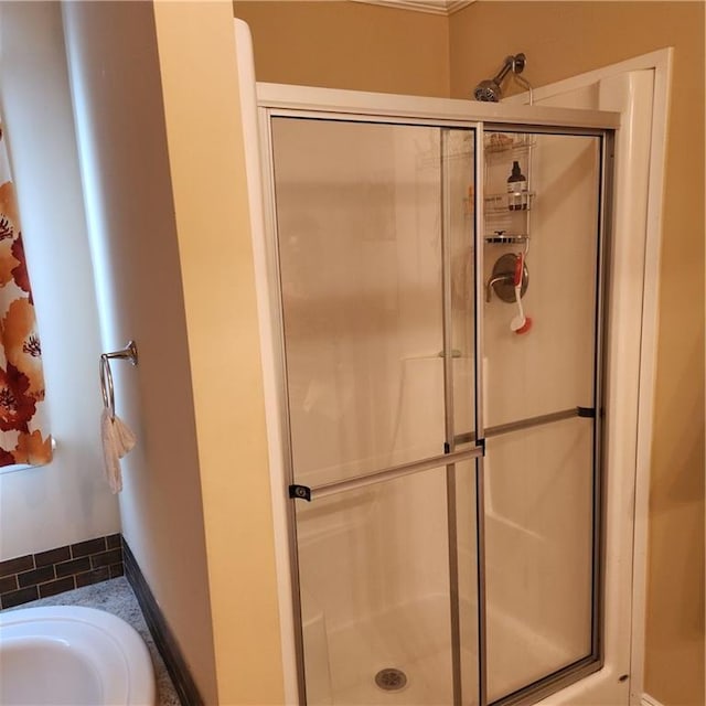 bathroom with a stall shower and a tub