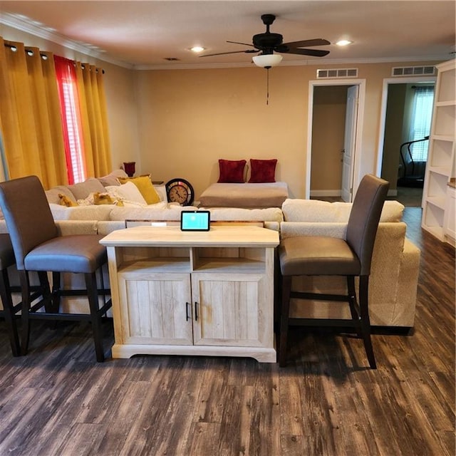 living room featuring crown molding, a ceiling fan, dark wood-style flooring, and visible vents