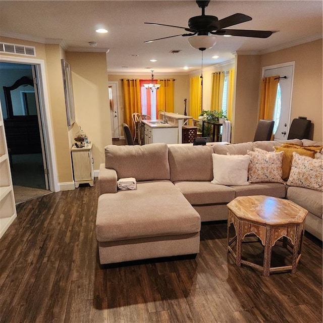 living area featuring visible vents, crown molding, ceiling fan with notable chandelier, dark wood-style floors, and recessed lighting