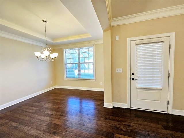 foyer entrance featuring a tray ceiling, crown molding, dark hardwood / wood-style floors, and a notable chandelier