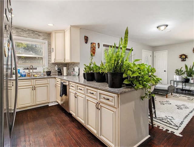 kitchen featuring cream cabinets, dark hardwood / wood-style flooring, sink, and light stone counters