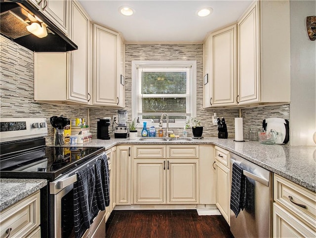 kitchen featuring cream cabinets, light stone countertops, and electric range