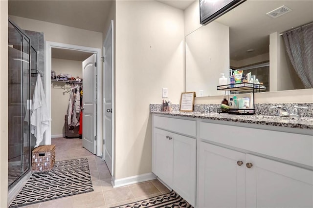 bathroom with tile patterned flooring, an enclosed shower, and vanity