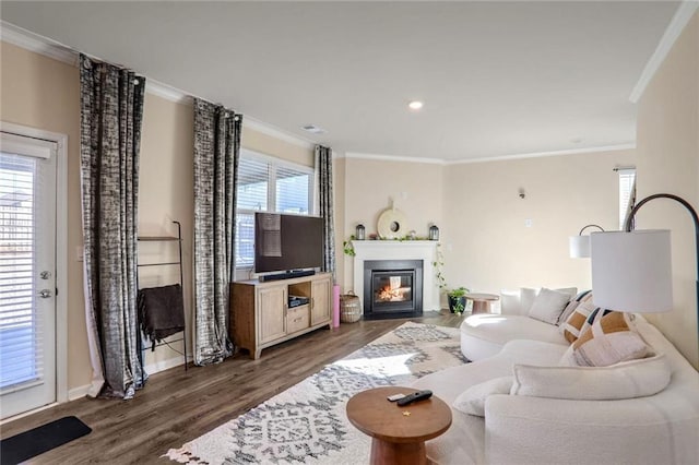 living room with plenty of natural light, dark hardwood / wood-style floors, and ornamental molding