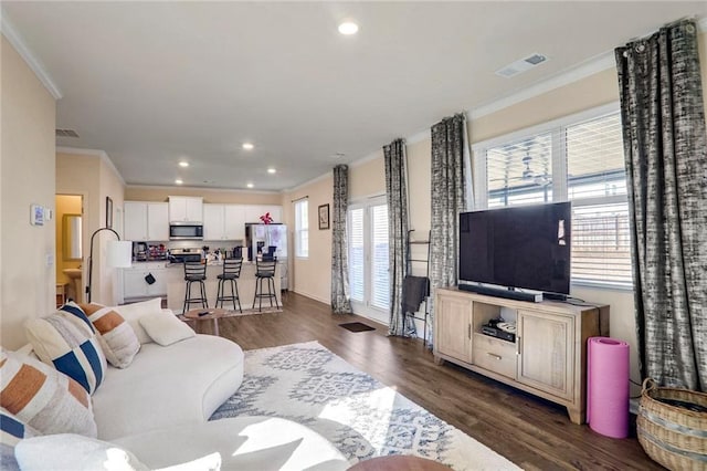 living room with dark hardwood / wood-style flooring and crown molding