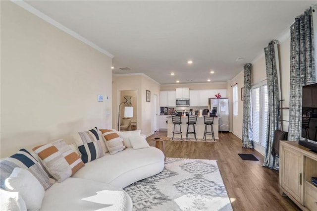 living room featuring crown molding and hardwood / wood-style floors