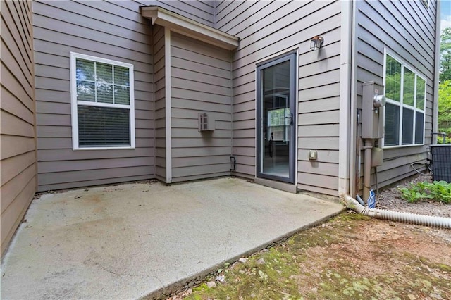 entrance to property with a patio area and central AC unit
