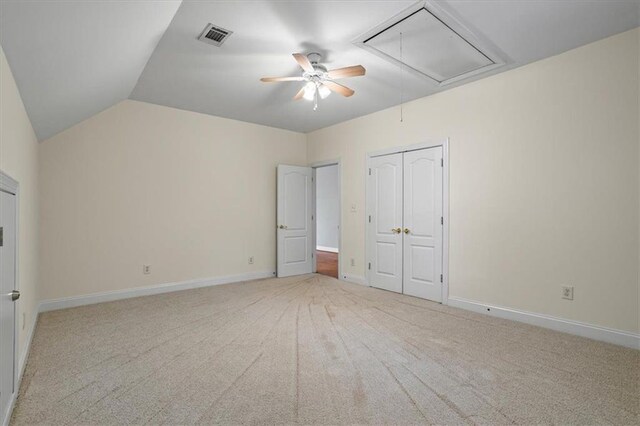 unfurnished bedroom featuring vaulted ceiling, light carpet, ceiling fan, and a closet