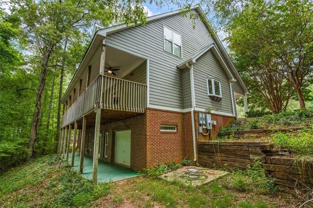 rear view of house with a garage and ceiling fan