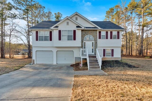 bi-level home featuring a garage and a front lawn