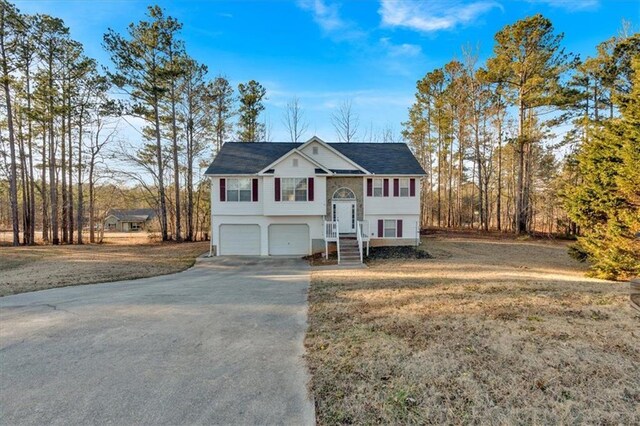 bi-level home featuring a garage and a front yard