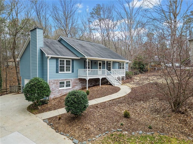 ranch-style house with a shingled roof, covered porch, and a chimney