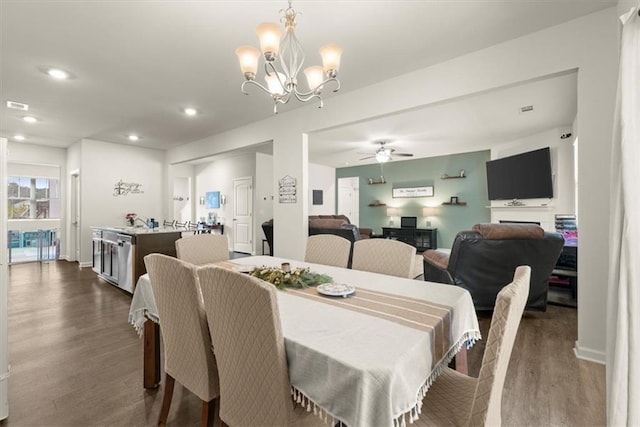 dining space with baseboards, ceiling fan with notable chandelier, dark wood-style flooring, and recessed lighting