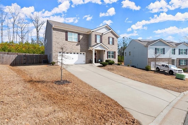 traditional-style house with driveway, a residential view, an attached garage, fence, and brick siding