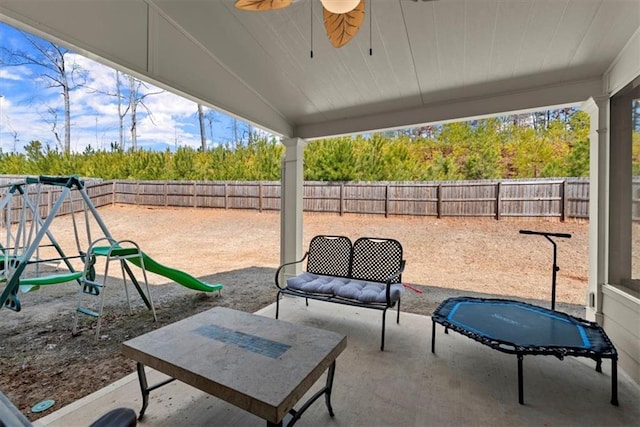 view of patio / terrace with a ceiling fan, a playground, and a fenced backyard