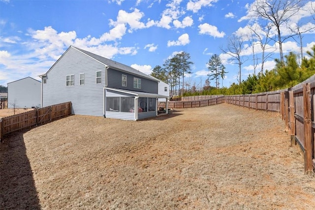 rear view of house featuring a sunroom and a fenced backyard